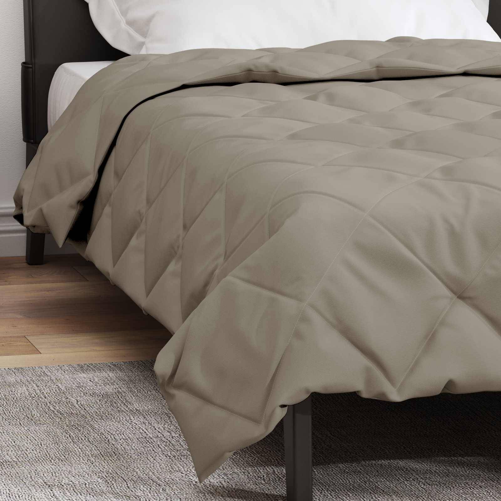 Ein ordentlich gemachtes Bett mit einer beigefarbenen gesteppten Tagesdecke, weißen Kissen und einem schwarzen Bettrahmen neben einem Holzboden und einem hellgrauen Teppich.
