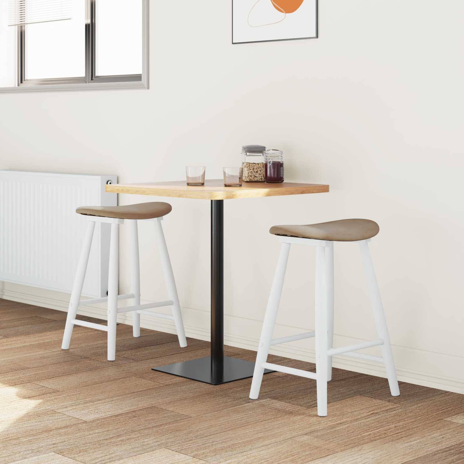 Ein kleiner Holztisch mit zwei Hockern in einer minimalistischen Kücheneinrichtung, mit einem Fenster und abstrakter Wandkunst.