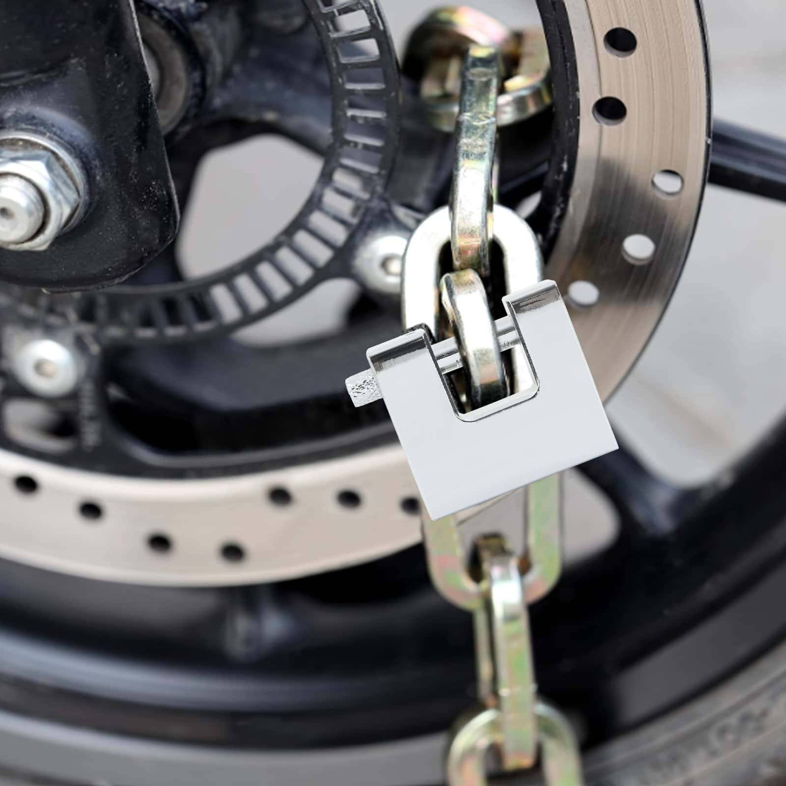 Eine Nahaufnahme einer Fahrradbremse mit Bremsscheibe, gesichert mit einer robusten Kette und einem Schloss, das Fahrradsicherheit und Diebstahlprävention symbolisiert.