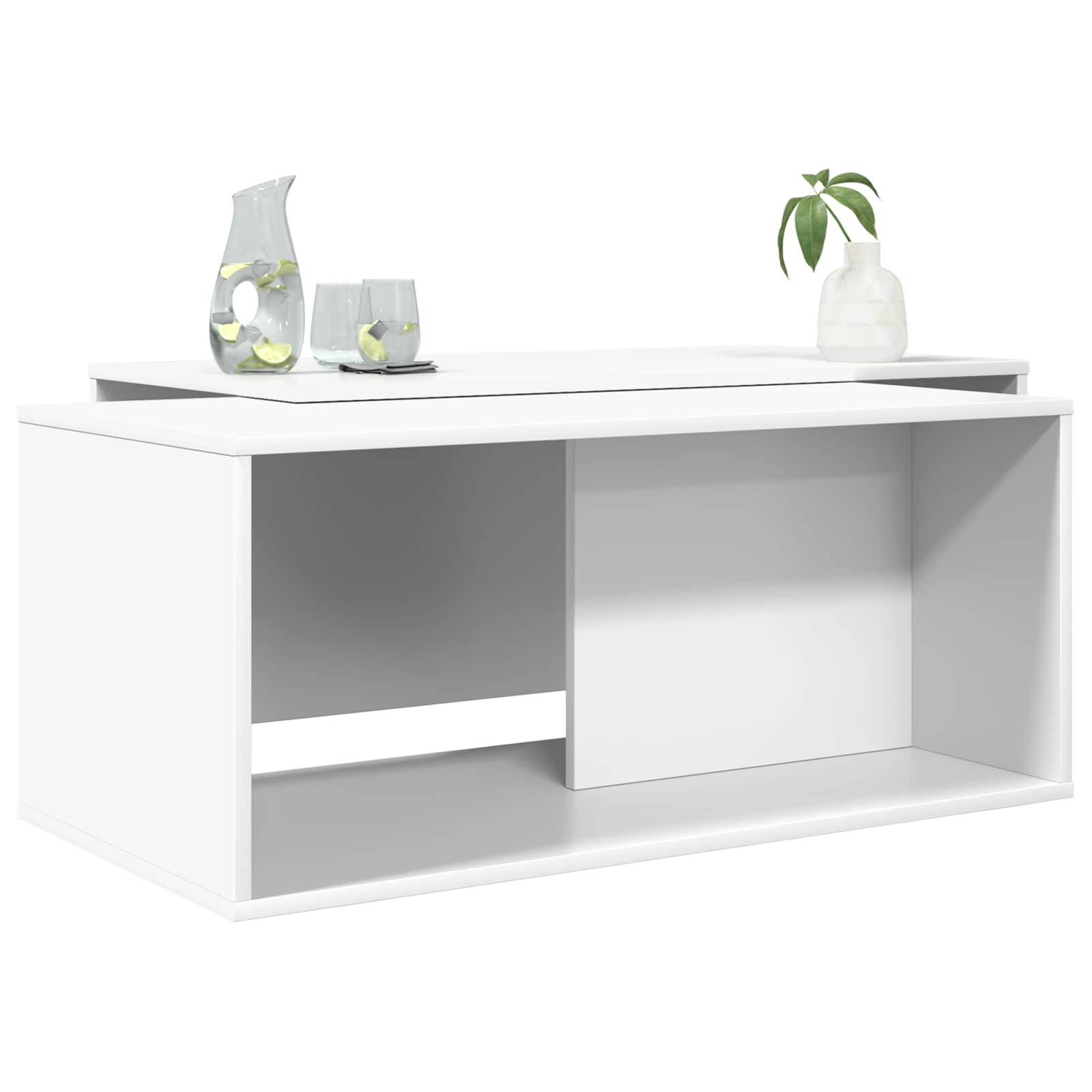 Ein moderner weißer Couchtisch mit rechteckiger Form verfügt über ein offenes Regal darunter. Oben steht eine Vase mit grünen Blättern und ein Krug mit Zitronen.