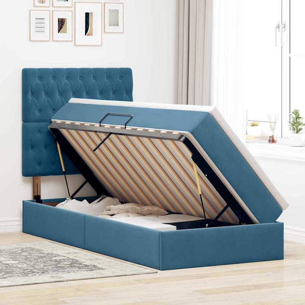 Ein blau gepolstertes Bett mit einem erhöhten Plattform-Stauraum unter der Matratze in einem hellen Raum mit gerahmter Kunst an der Wand.