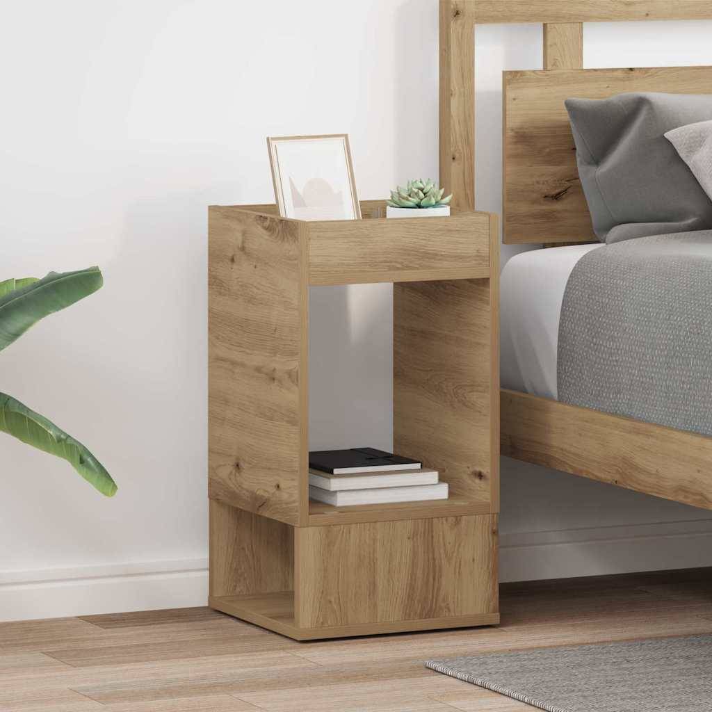 Holzerner Nachttisch mit Büchern und einem gerahmten Foto neben einem gemachten Bett mit grauen und weißen Kissen. Ein Pflanzenblatt schaut in die Szene hinein.