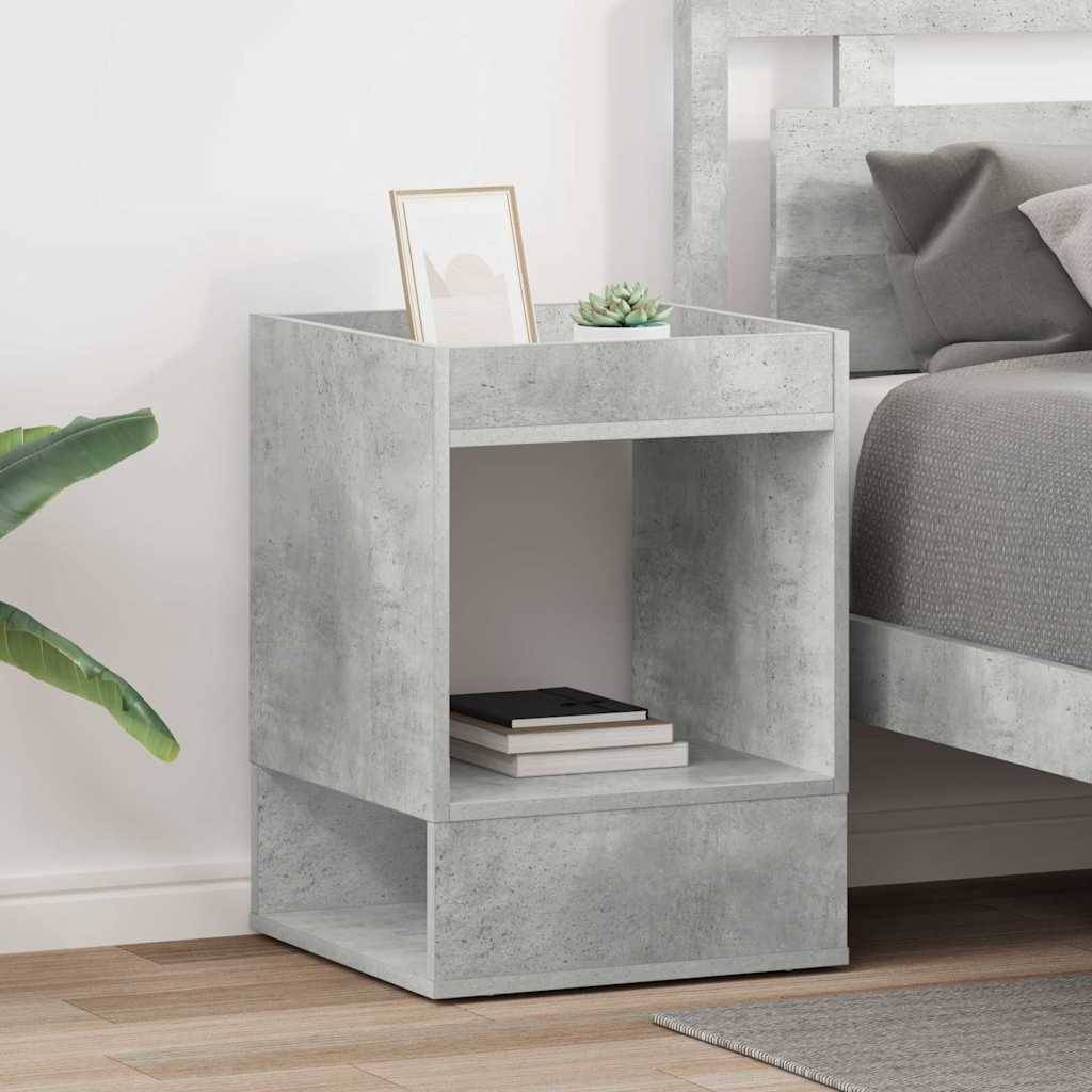 Ein moderner grauer Betonnachttisch mit einem offenen Regal, auf dem Bücher, eine Pflanze und ein Rahmenbild präsentiert werden, neben einem Bett.