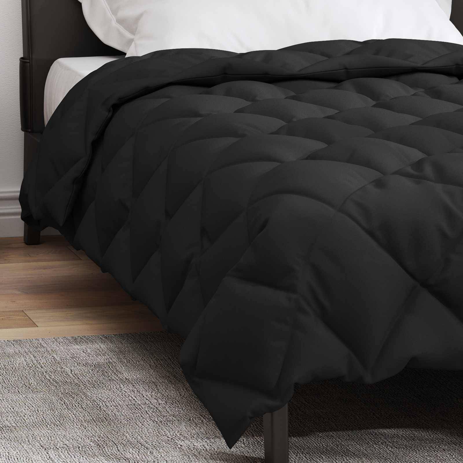 Ein ordentlich gemachtes Bett mit einem weißen Kissen und einer schwarzen gesteppten Decke, die über die Kante drapiert ist, in einem Zimmer mit hellem Holzboden.