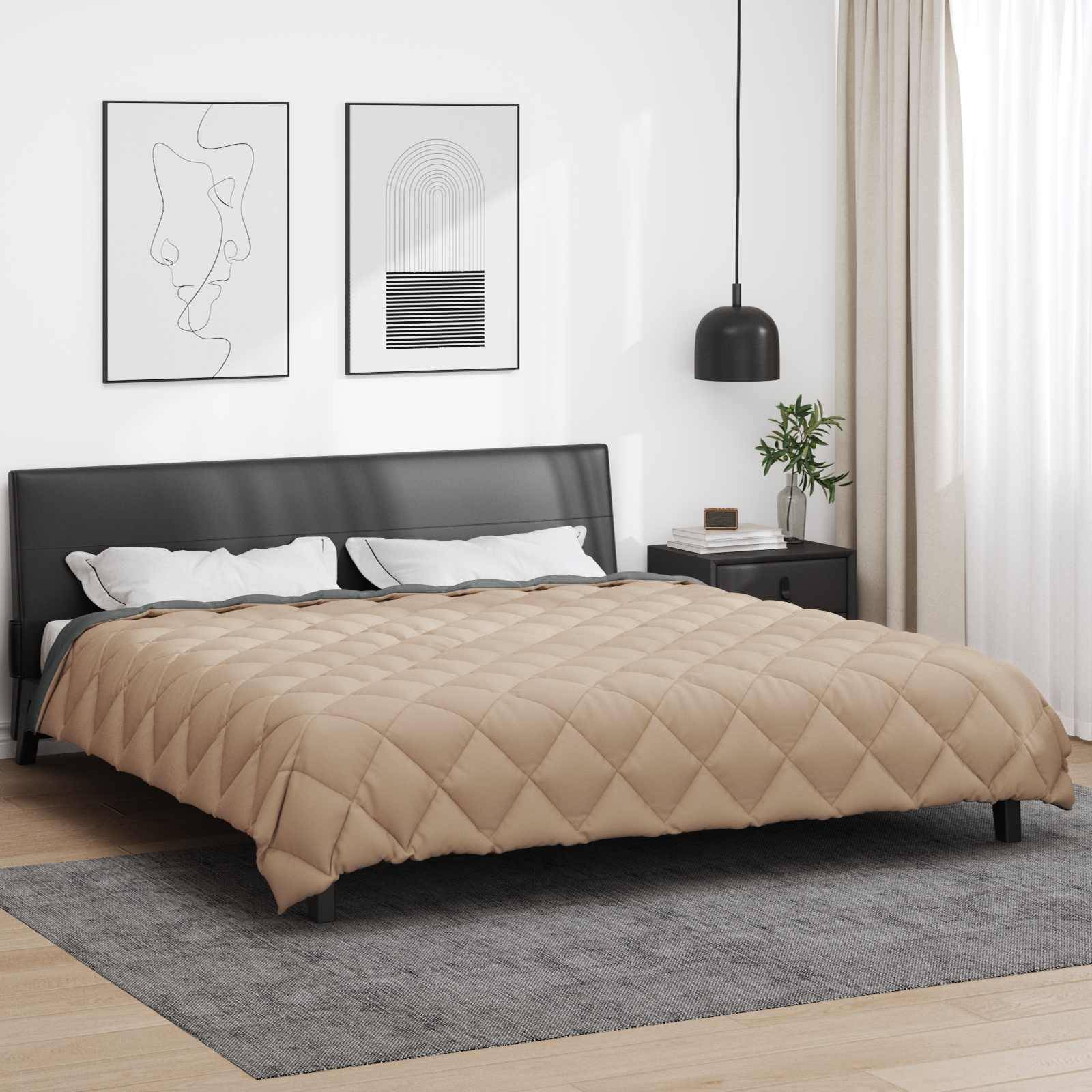 Ein sorgfältig gemachtes Bett mit einer beige-farbenen Steppdecke in einem modernen Schlafzimmer mit schwarz-weißer Wandkunst, einer schwarzen Pendelleuchte und leichten Vorhängen.