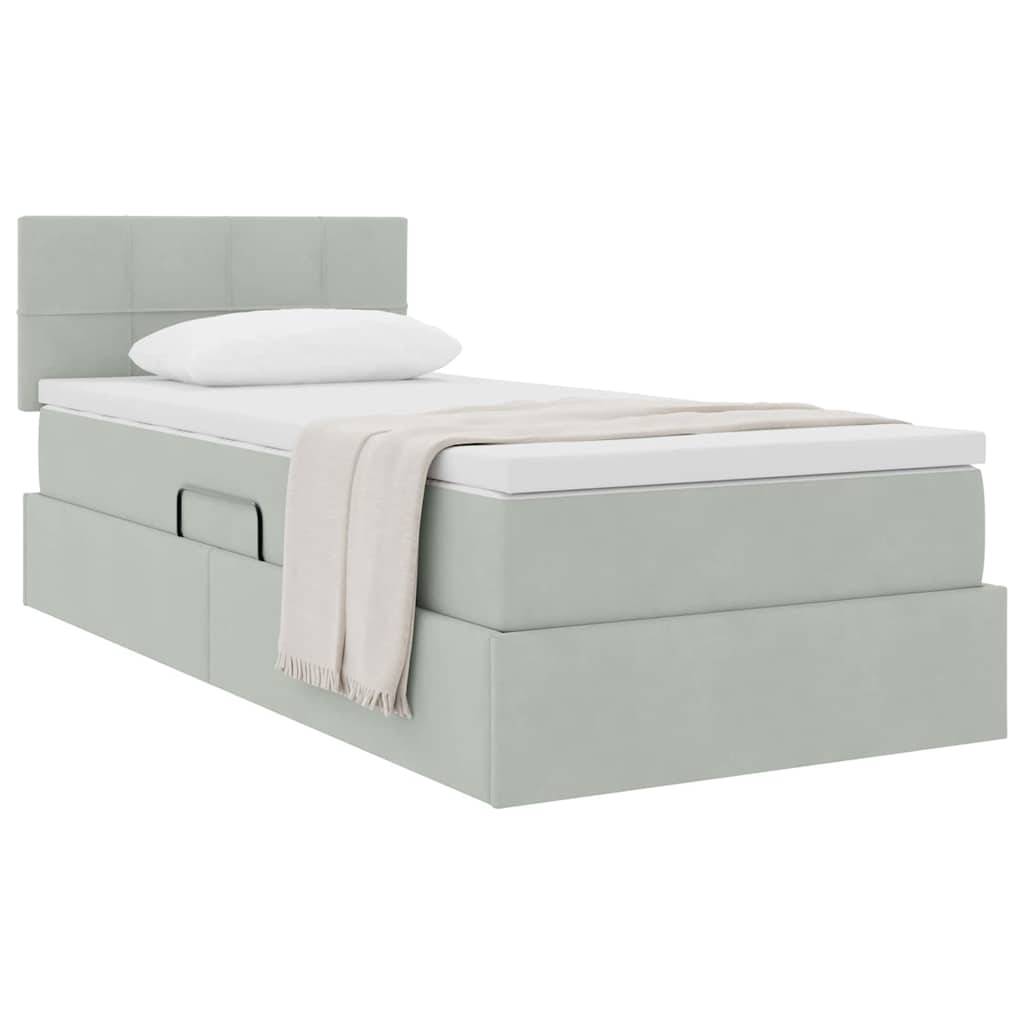 Ein hellgraues gepolstertes Einzelbett mit hohem Kopfteil, weißem Kissen, beigem Plaid und seitlichen Aufbewahrungsschubladen in einem sauberen, minimalistischen Stil.