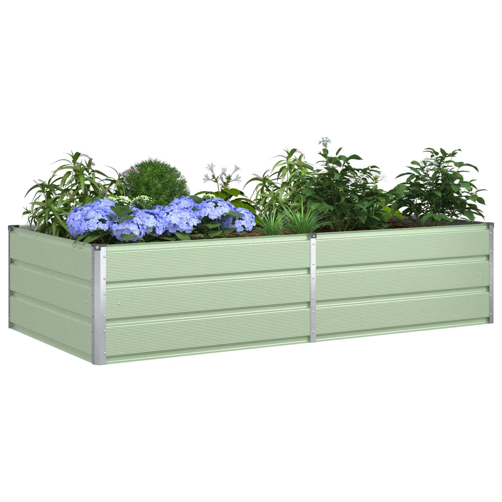 Eine große Blumenkiste mit grünen Pflanzen steht vor einem Holzzaun, mit Bäumen, die im Hintergrund sichtbar sind. Die Szene spielt sich im Freien ab und deutet auf einen Garten hin.