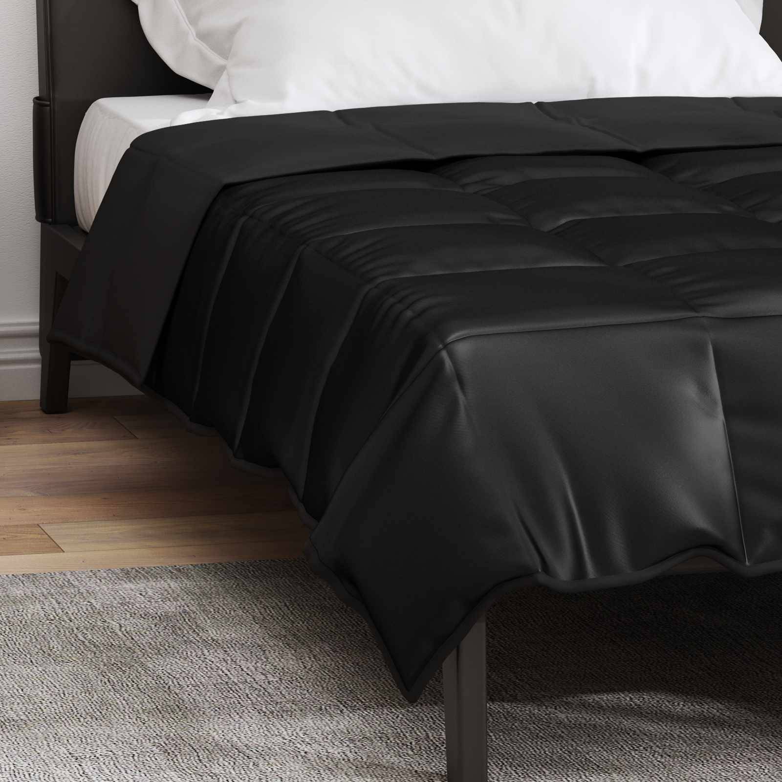 Ein ordentlich gemachtes Bett mit weißen Kissen und einer schwarzen Bettdecke in einem schlicht eingerichteten Schlafzimmer mit Holzfußboden.