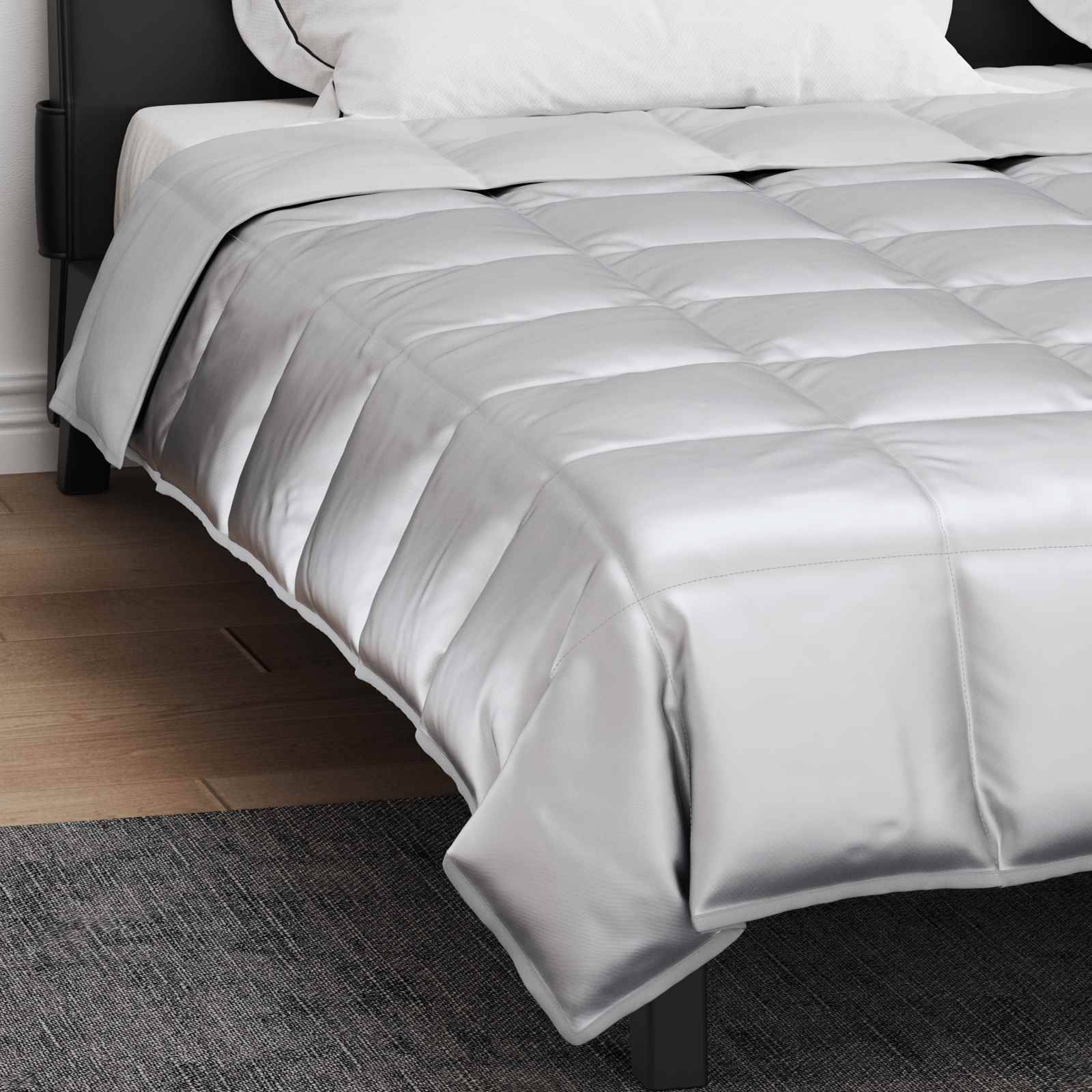 Ein sorgfältig gemachtes Bett mit einer dicken, silbergrauen, gesteppten Bettdecke und weißen Kissen, eingerichtet in einem modernen Schlafzimmer mit Holzböden und dunklen Möbeln.