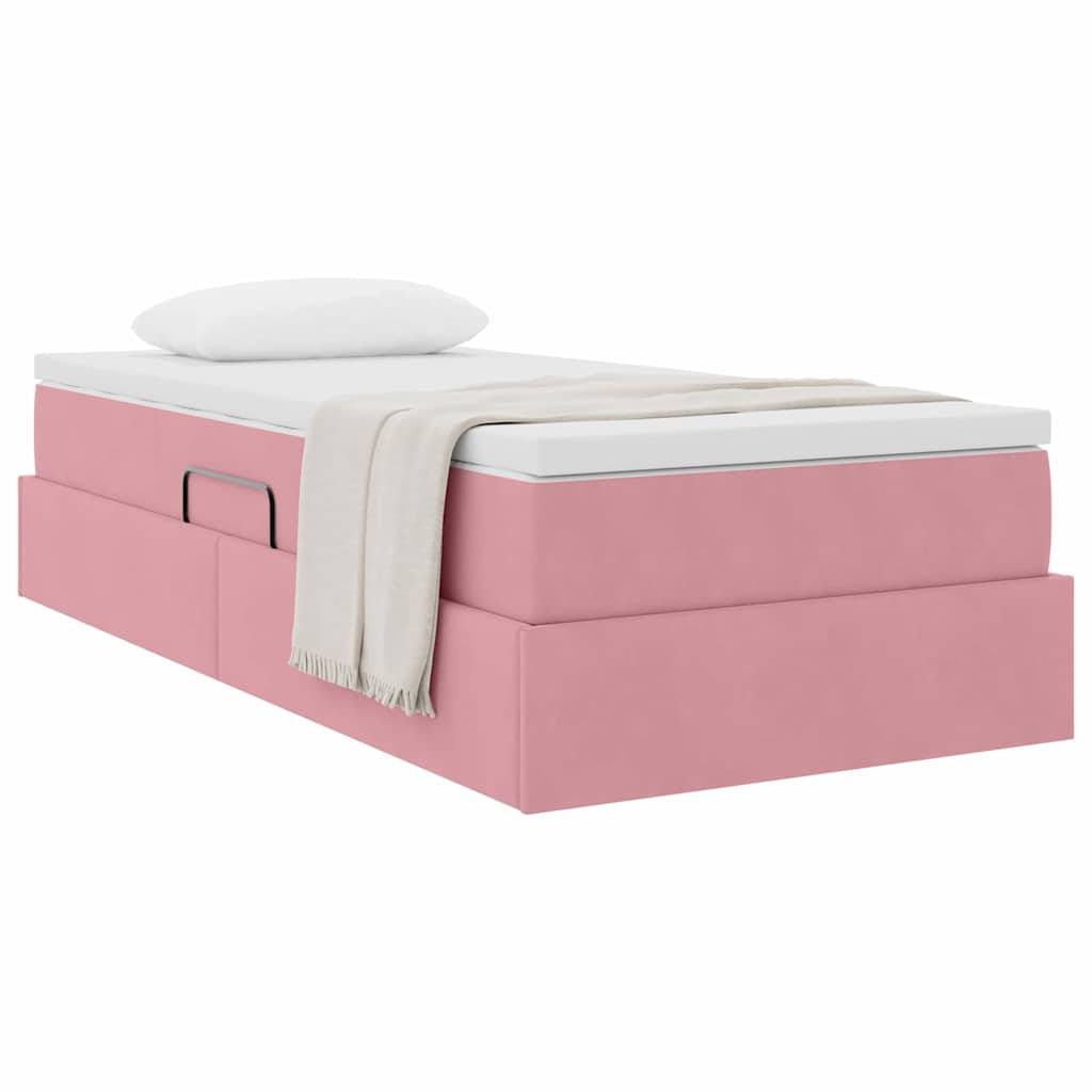 Ein gestepptes graues Bett mit hohem Kopfteil, weißen Laken und zwei Kissen. Eine hellbeige Decke ist über das Fußende des Bettes drapiert.