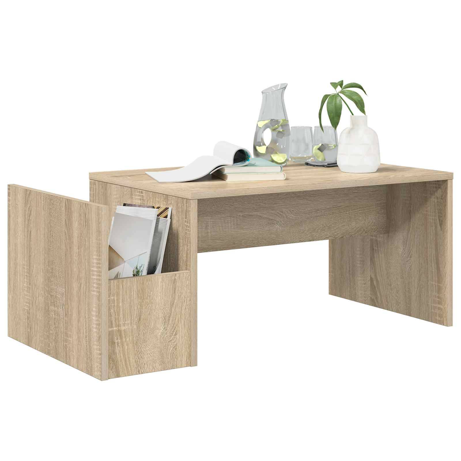 Ein Holz-Couchtisch mit integriertem seitlichen Zeitschriftenständer. Oben liegen ein aufgeschlagenes Buch, eine Glaskanne und eine Pflanze in einer Vase.