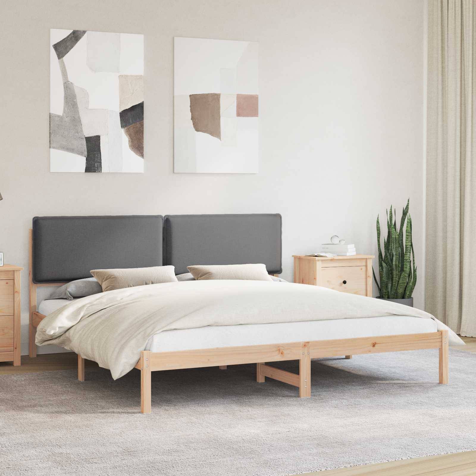 Ein modernes Schlafzimmer mit einem grau gepolsterten Bett, hellem Holzmöbel, abstrakten Wandkunstwerken und einer Topfpflanze für ein minimalistisches Design.