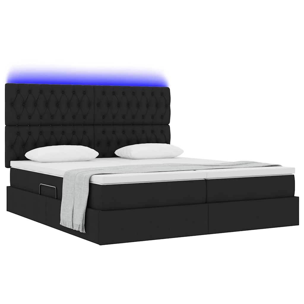Ein modernes schwarzes Doppelbett mit gestepptem Kopfteil, weißer Bettwäsche und einer hellgrauen Wurfdecke. Das Kopfteil hat eine blaue LED-Lichtakzent.