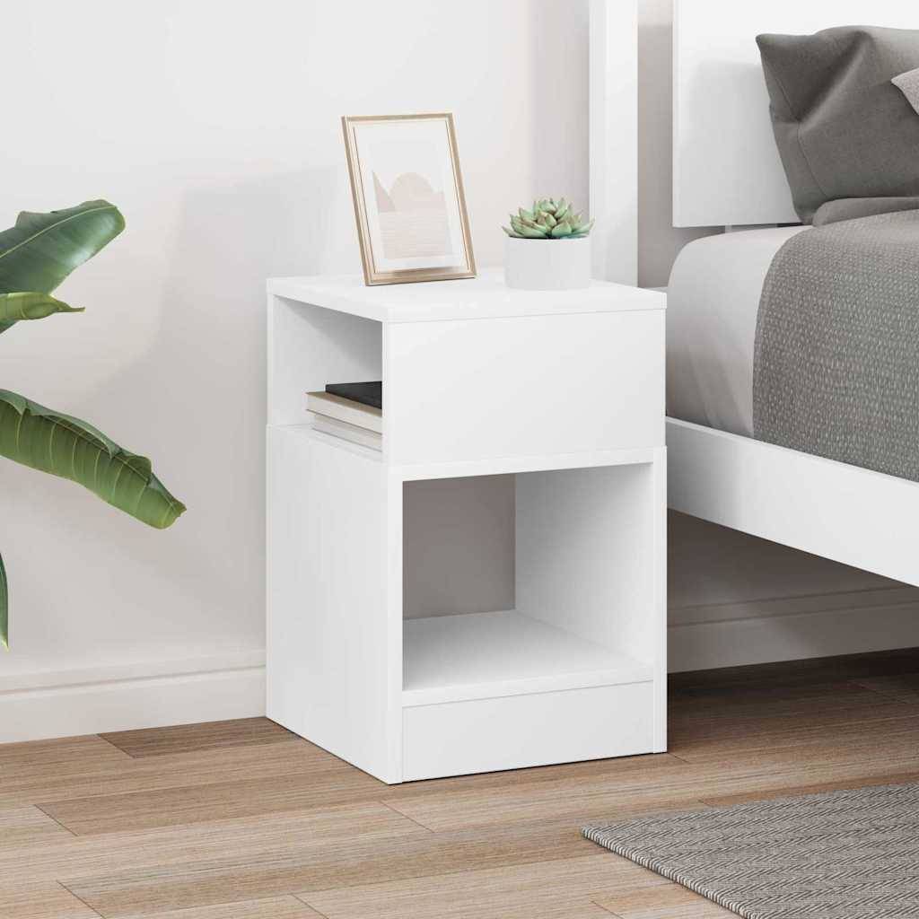 Ein Holzbeistelltisch mit einem offenen Regal, auf dem eine kleine Vase mit einer Pflanze und eine weiße Tasse stehen, neben einem hellfarbigen Sofa in einem Wohnzimmer.