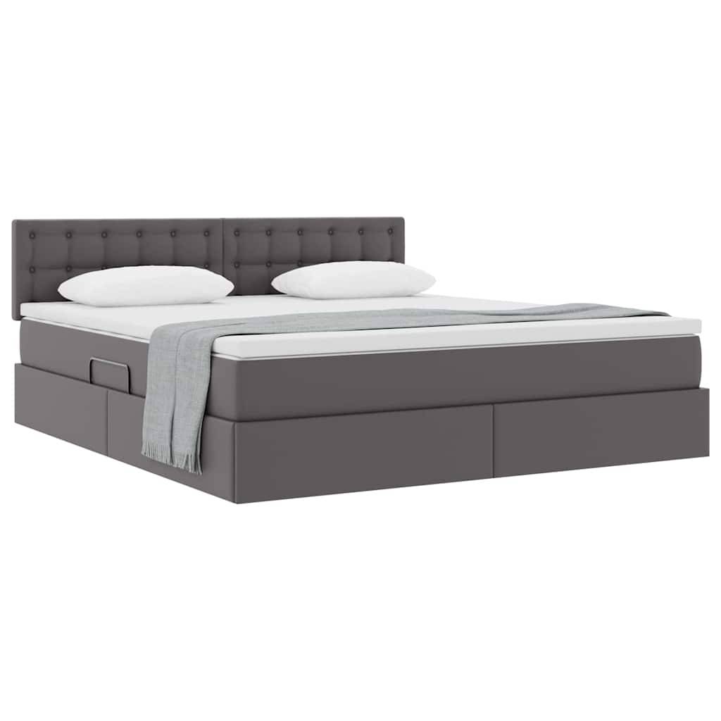 Ein modernes grau gepolstertes Bett mit einem mit Knöpfen gestepptem Kopfteil, ausgestattet mit weißen Kissen und einer hellgrauen Decke, die über die Kante drapiert ist.