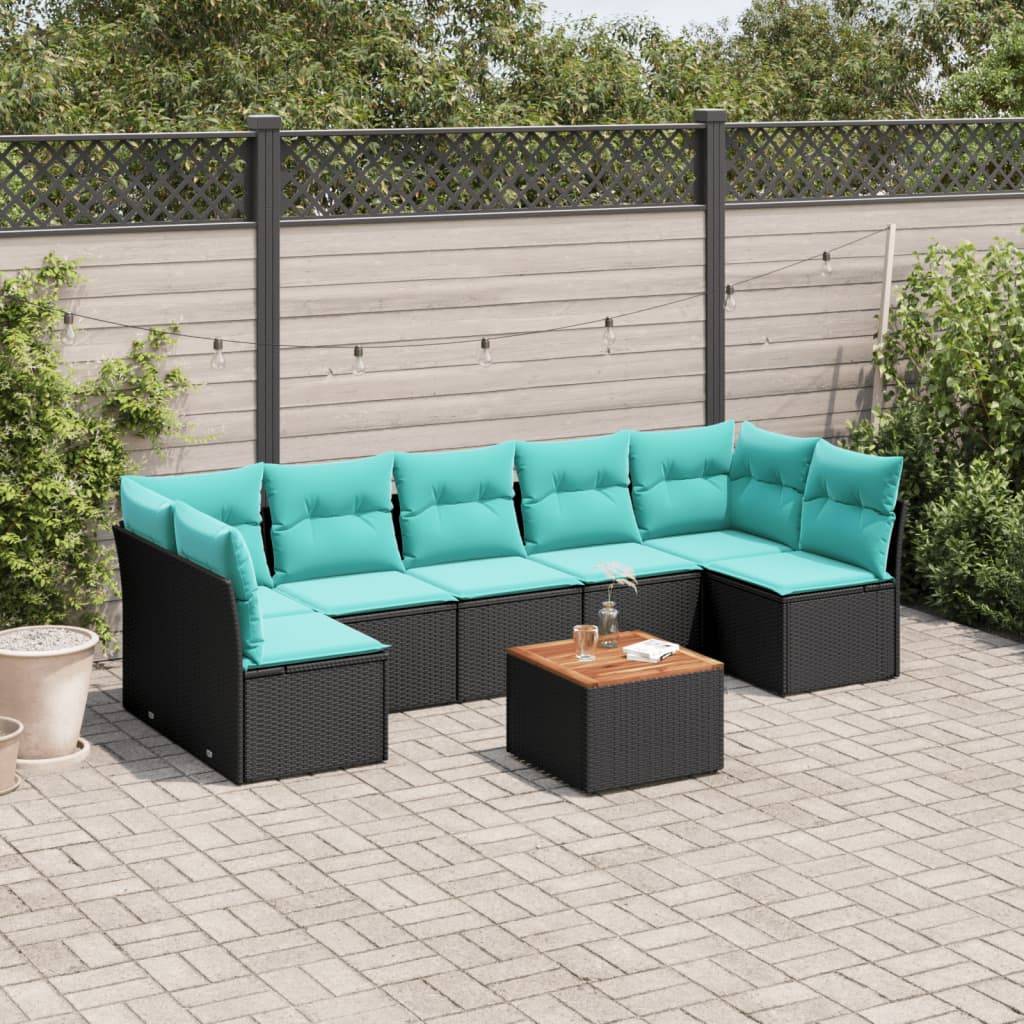 Ein schwarzes Outdoor-Ecksofa mit türkisfarbenen Kissen steht auf einer Terrasse neben einem Holztisch. Ein Holzzaun und Bäume sind im Hintergrund zu sehen.