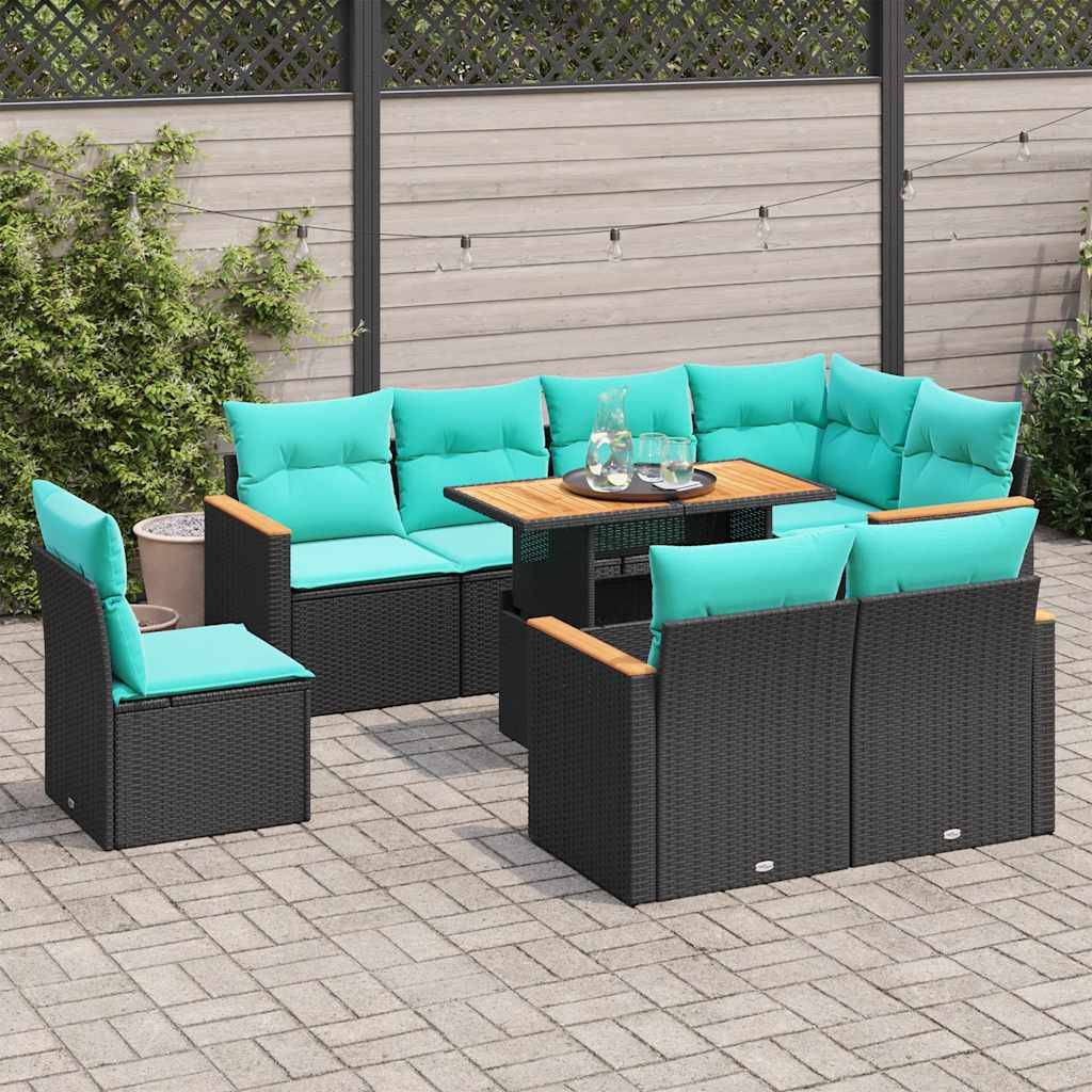 Outdoor-Terrasse mit schwarzem Rattanmöbel-Set, türkisfarbenen Kissen und einem Holztisch. Grüne Pflanzen und ein Holzzaun befinden sich im Hintergrund.