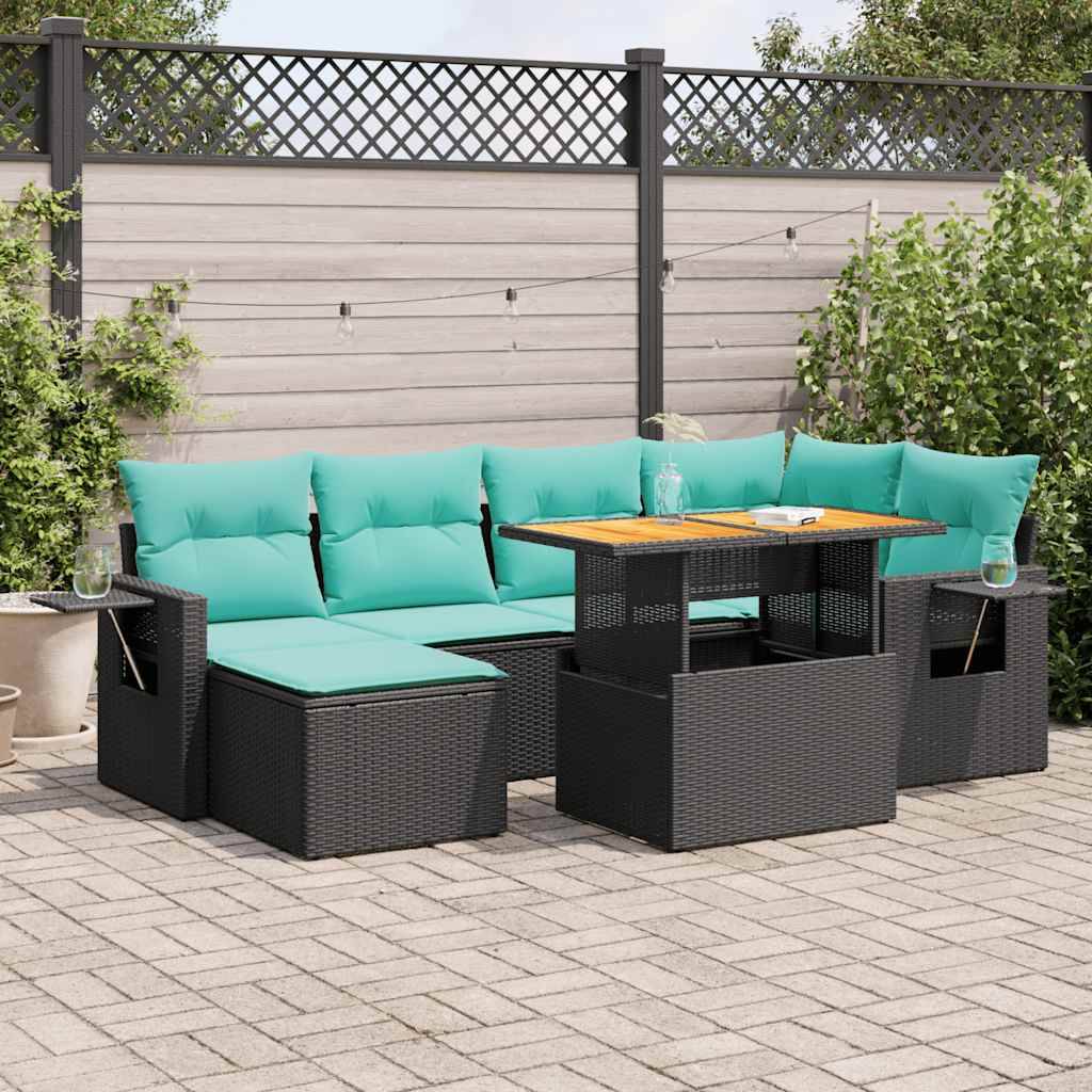 Outdoor-Terrassenmöbel mit türkisen Kissen, Glastisch und grauem Rattanmöbel auf einer Natursteinoberfläche, umgeben von einem Zaun mit Pflanzen in der Nähe.