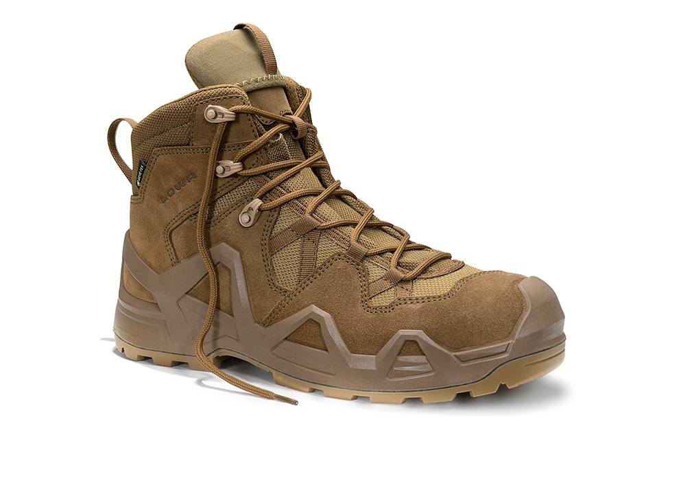 Ein beige, robuster Wanderschuh mit hochgeschnittenem Schaftdesign, strapazierfähiger Sohle und Schnürverschluss, geeignet für Outdoor-Aktivitäten.