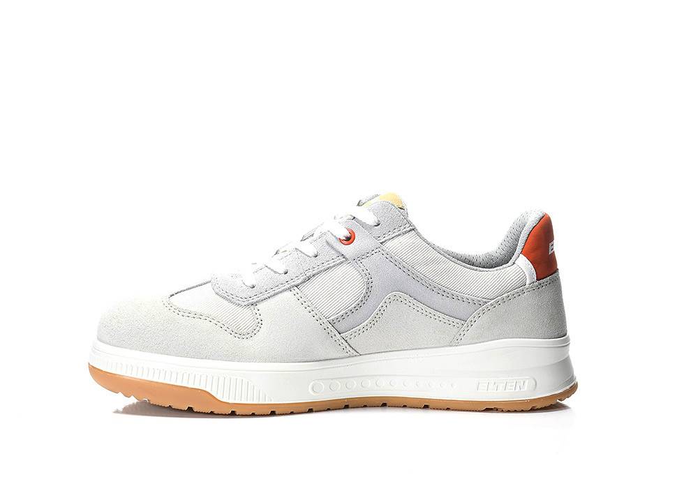 Ein hellgrauer Sneaker mit orangefarbenen Akzenten an der Ferse und der Sohle wird vor weißem Hintergrund gezeigt. Der Schuh hat ein niedriges Schnittdesign.