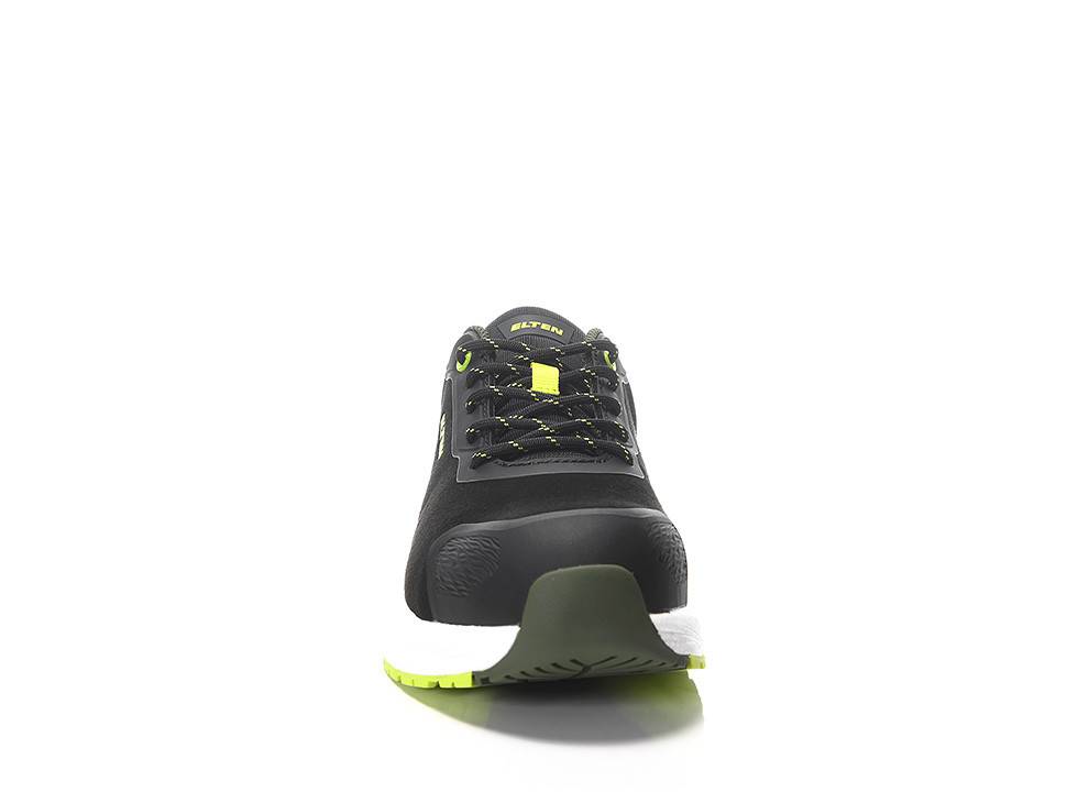 Ein schwarzer und grüner Sportschuh von vorne, die Sohlenstruktur und das Schnürdesign vor weißem Hintergrund zeigend.