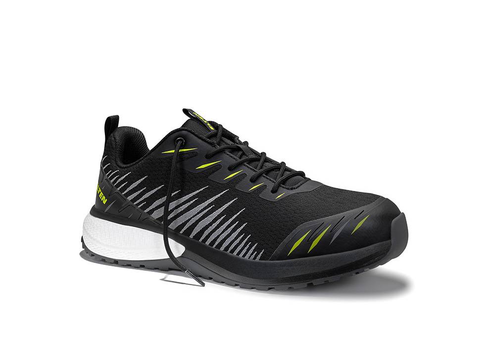 Ein schwarzer Sportschuh mit weißen und grünen Akzenten, mit einer strukturierten Sohle und einer Lasche an der Ferse, vor einem weißen Hintergrund platziert.