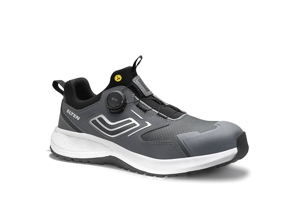 Ein grauer Sportschuh mit weißer Sohle, mit schwarzer Zunge und einem Schnürverschlussmechanismus, konzipiert für Komfort und Langlebigkeit.