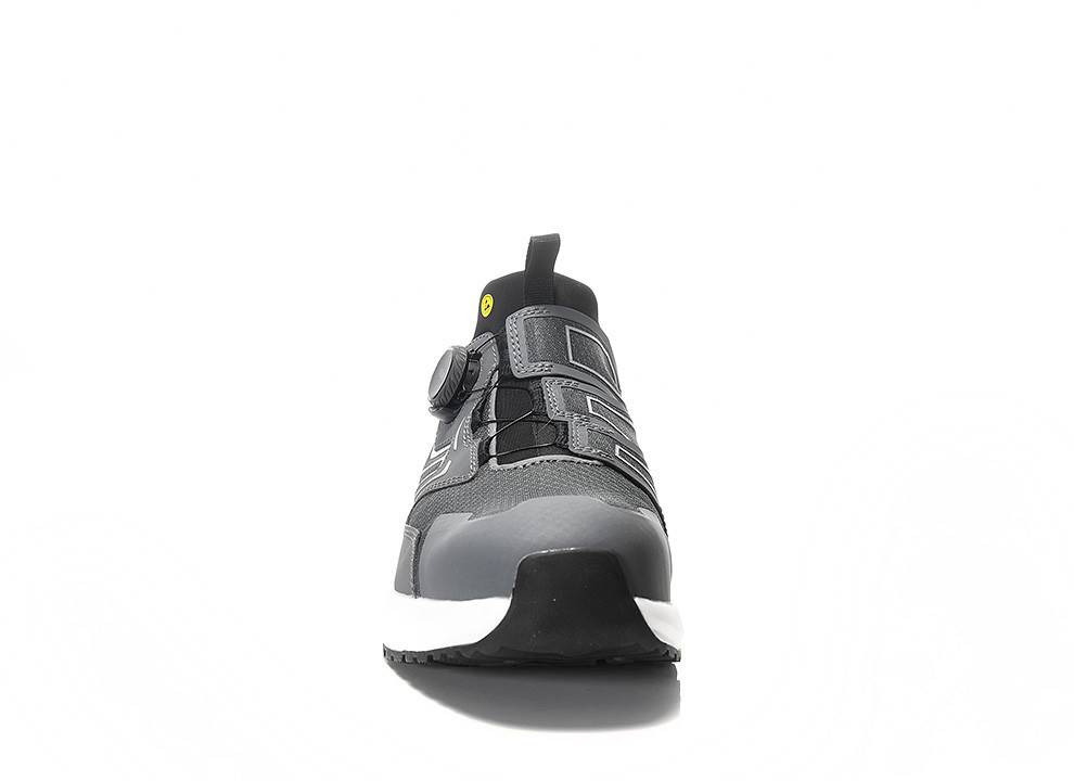 Ein grau-schwarzer Trailrunning-Schuh mit robuster Sohle, mit gelbem Detail nahe den Schnürsenkeln, auf weißem Hintergrund dargestellt.