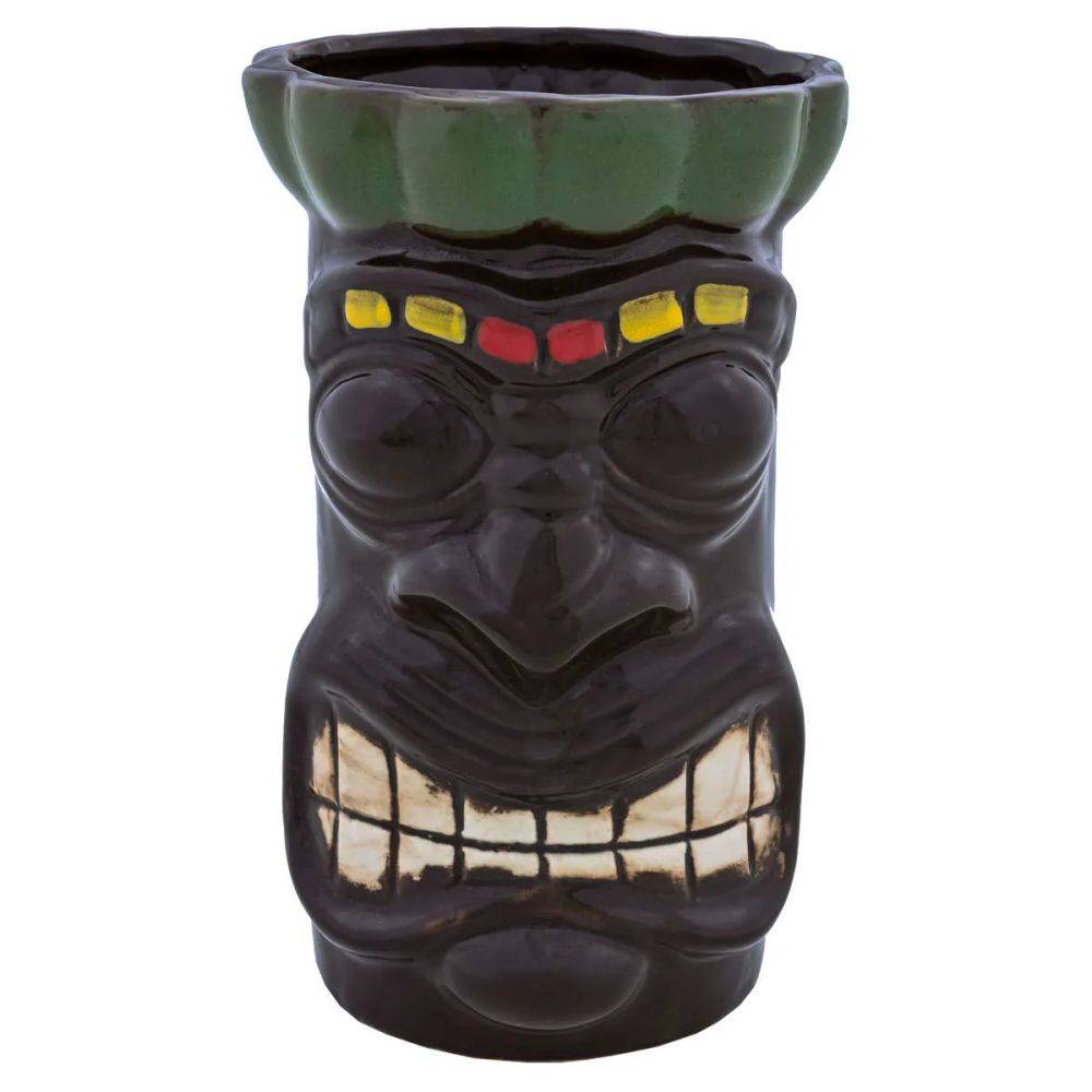 Eine Keramiktasse in Form eines Tiki-Gesichts mit breitem Zahnlachen, farbenfrohen Stirnaccessoires und grünem Rand.