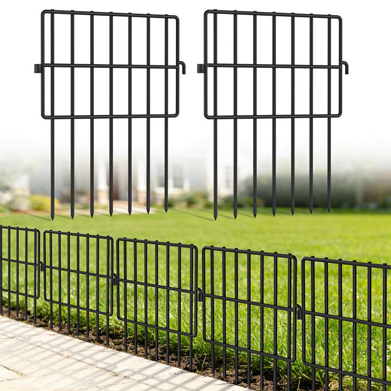 Ein grüner Rasen, umgeben von schwarzem dekorativem Metallzaun mit vertikalen Stäben, vor einem unscharfen Gartenhintergrund.