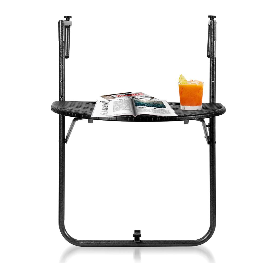 Ein schwarzer Klapptisch hält ein aufgeschlagenes Magazin und ein Glas Orangensaft mit einer Orangenscheibe als Garnierung.