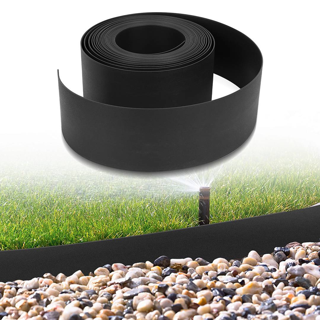 Eine Rolle schwarze Landschaftseinfassung neben Gras und Mulch, mit einem Sprinkler, der den Rasen bewässert und die Installation von Garteneinfassungen veranschaulicht.