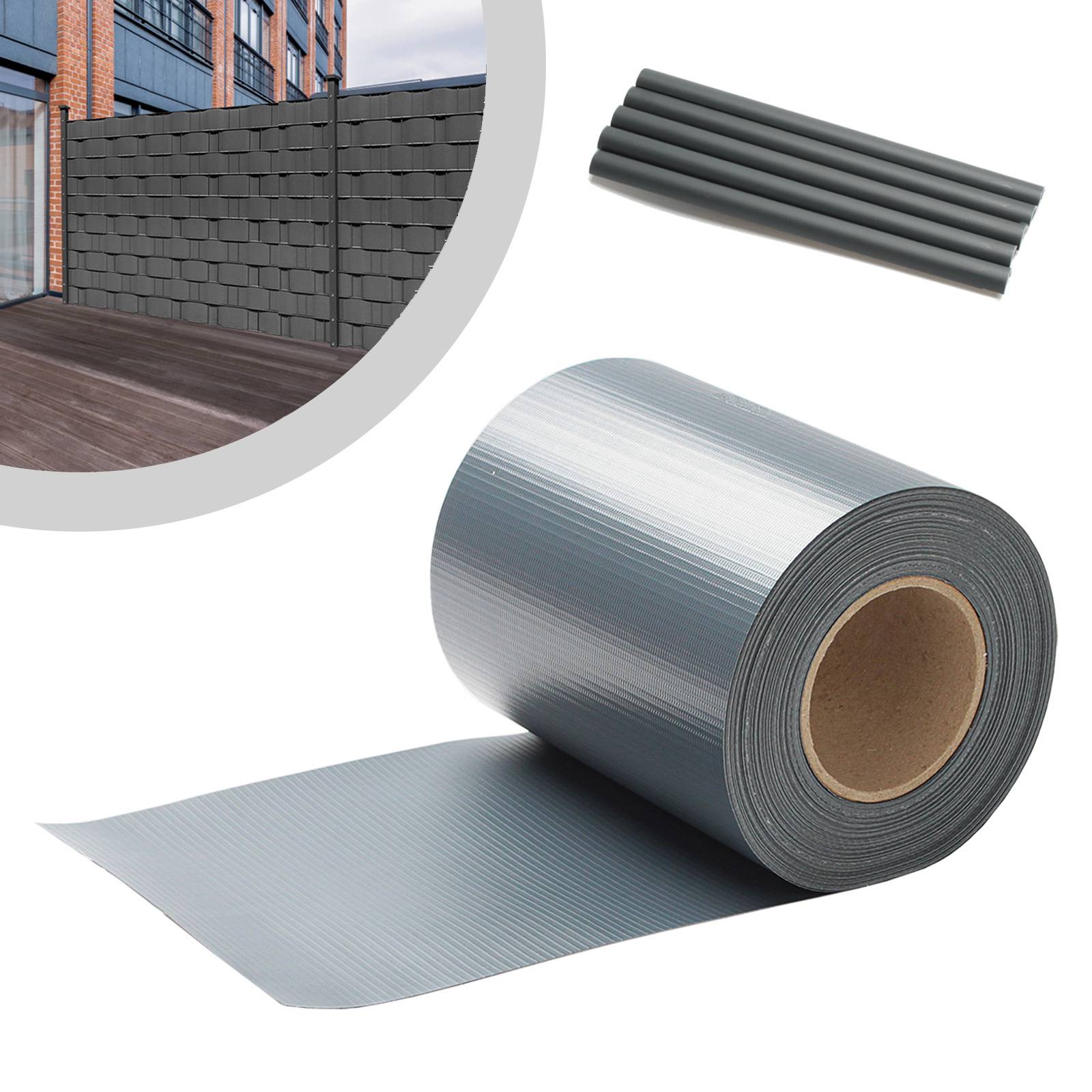 Eine Rolle graues Zaunerblendungsmaterial und Stäbe mit einem Hintergrund, der einen hohen grauen Sichtschutzzaun in einer städtischen Umgebung zeigt.