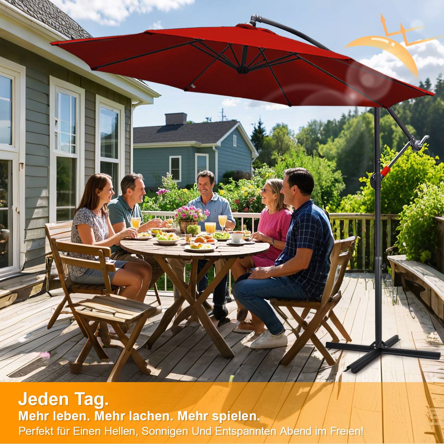 Fünf Personen sitzen an einem Terrassentisch im Freien unter einem großen roten Schirm und genießen eine Mahlzeit. Text liest sich wie folgt: „Jeden Tag. Mehr leben. Mehr lachen. Mehr spielen.