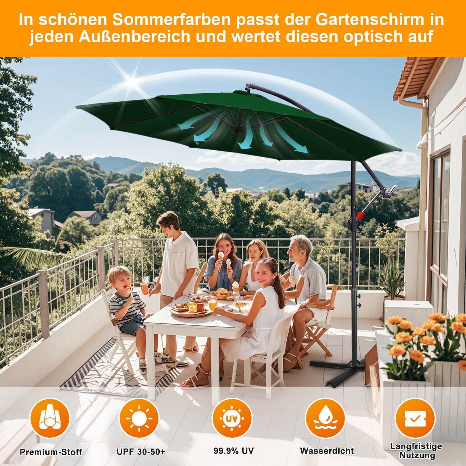Eine Gruppe von Menschen genießt das Mittagessen auf einer sonnigen Terrasse unter einem großen grünen Gartenschirm. Hügel und Grünflächen befinden sich im Hintergrund.