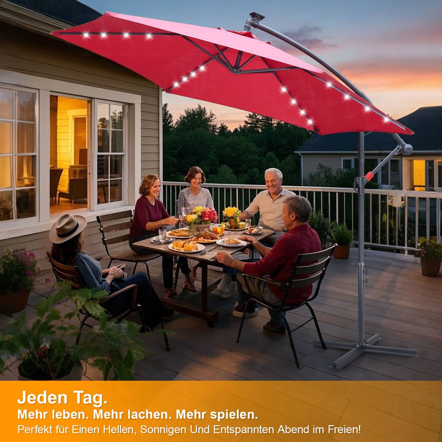 Ein älteres Ehepaar und Freunde speisen bei Einbruch der Dämmerung auf einer Terrasse im Freien unter einem großen roten Schirm mit LED-Lichtern. Text in Deutsch unten.