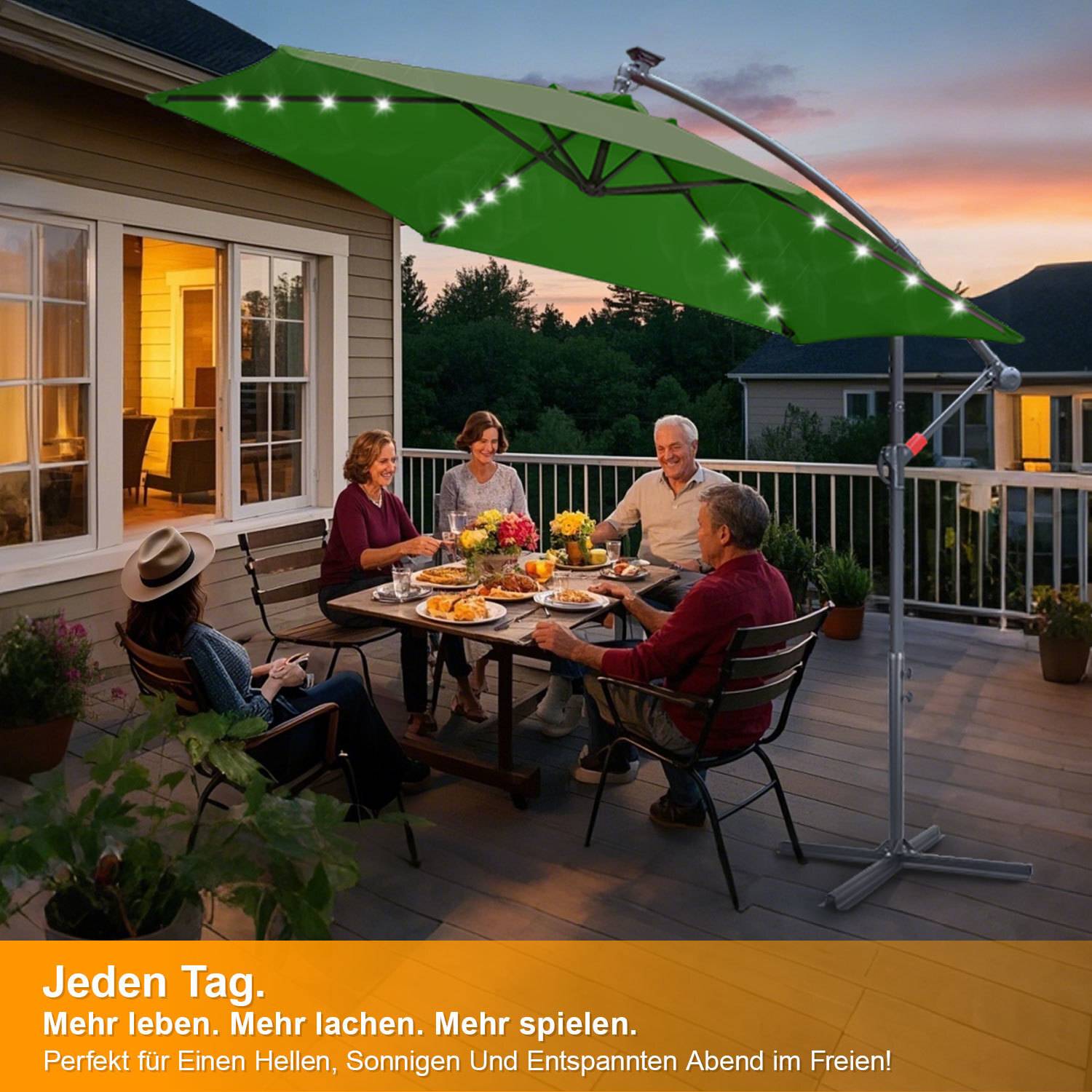 Vier Personen sitzen an einem Terrassentisch und genießen am Abend eine Mahlzeit unter einem großen, beleuchteten Außenschirm. Die Atmosphäre ist entspannt und gesellig.