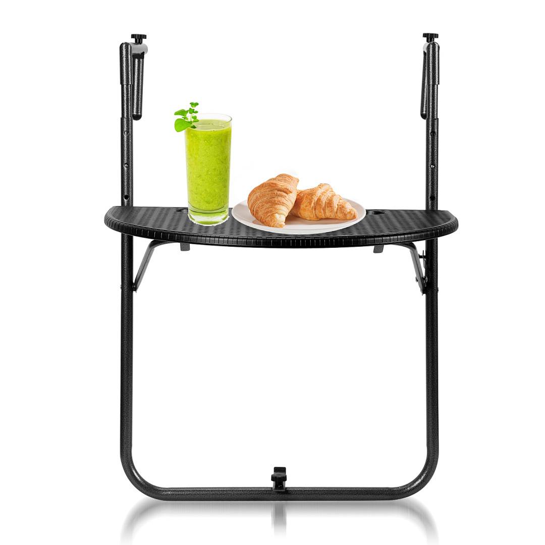 Ein zusammengeklappter schwarzer Tabletttisch mit einem Teller Croissants und einem grünen Smoothie obendrauf.