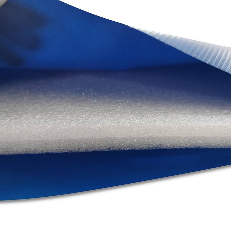 Nahaufnahme geschichteter Materialien: eine blau strukturierte äußere Schicht und eine weiße innere Schicht, möglicherweise als Hinweis auf Isolierung oder Polsterung.