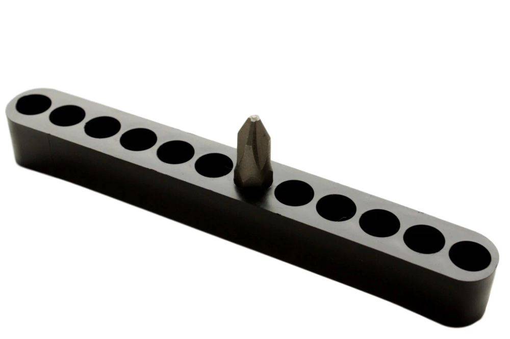 Ein schwarzer Magnetstreifen hält einen Schraubendreheraufsatz aufrecht, umgeben von leeren kreisförmigen Aussparungen für zusätzliche Aufsätze, vor einem weißen Hintergrund.