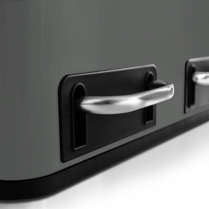 Eine Nahaufnahme von eleganten, metallischen Griffen auf einem modernen, dunkelgefärbten Küchengerät, das Design und Funktionalität hervorhebt.