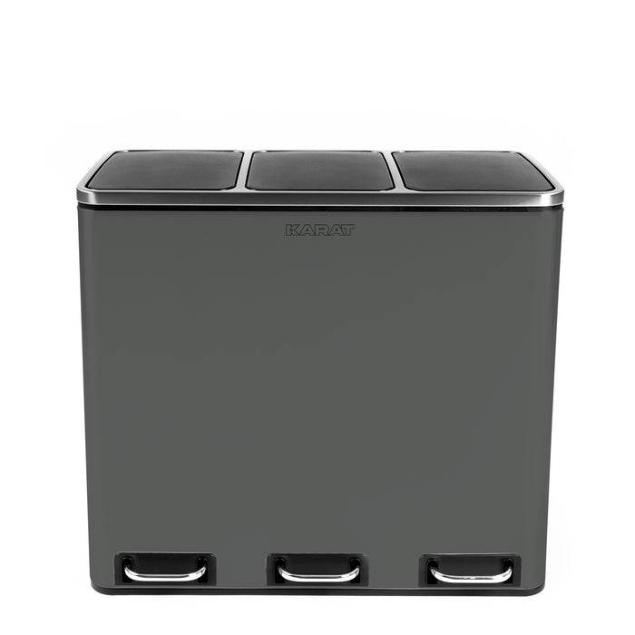 Ein dunkelgrauer rechteckiger Behälter mit drei Fußpedalen und drei Fächern oben, entworfen zur Abfalltrennung und zum Recycling.