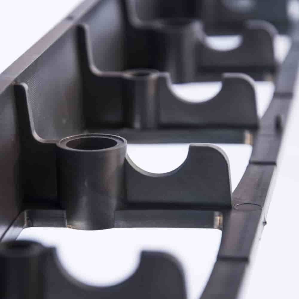 Nahaufnahme eines schwarzen Kunststoff-Werkzeugorganizers mit mehreren abgerundeten Fächern, die zum Aufbewahrung zylindrischer Werkzeuge oder Teile konzipiert sind.