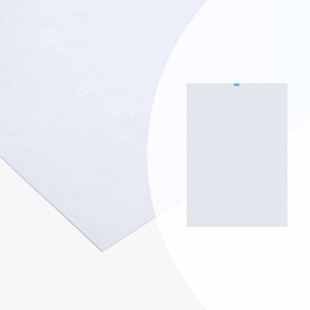 Ein Nahaufnahmebild, das eine Ecke eines weißen Blattes Papier auf einer flachen Oberfläche zeigt, mit einem kleinen, schlichten Stück Papier, das es auf der rechten Seite überlagert.