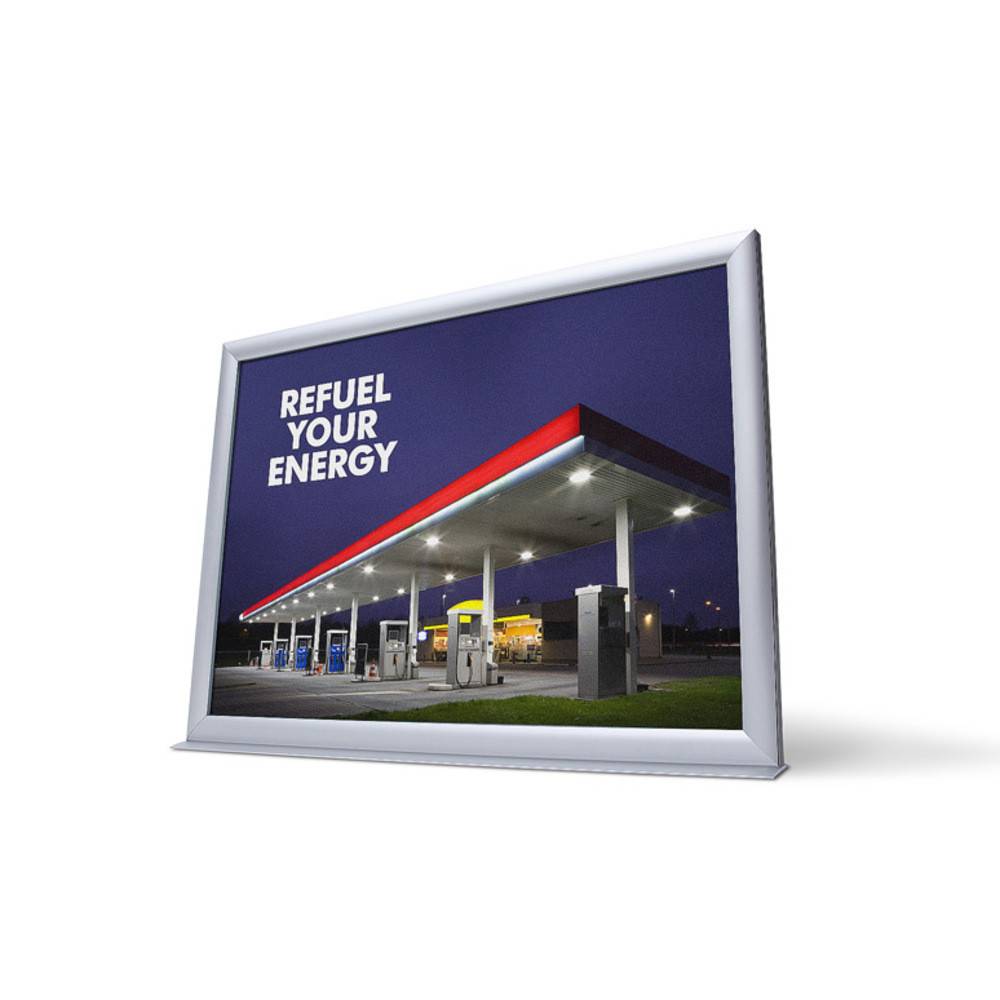 Eine beleuchtete Tankstelle in der Nacht mit dem Slogan „Tanken Sie Ihre Energie auf