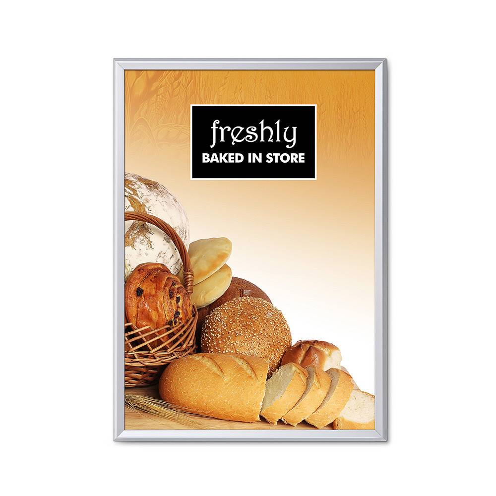 Eine Vielfalt von frisch gebackenem Brot, einschließlich Laibe und Brötchen, in einem Korb ausgestellt unter einem Schild, auf dem „Frisch Im Laden Gebacken