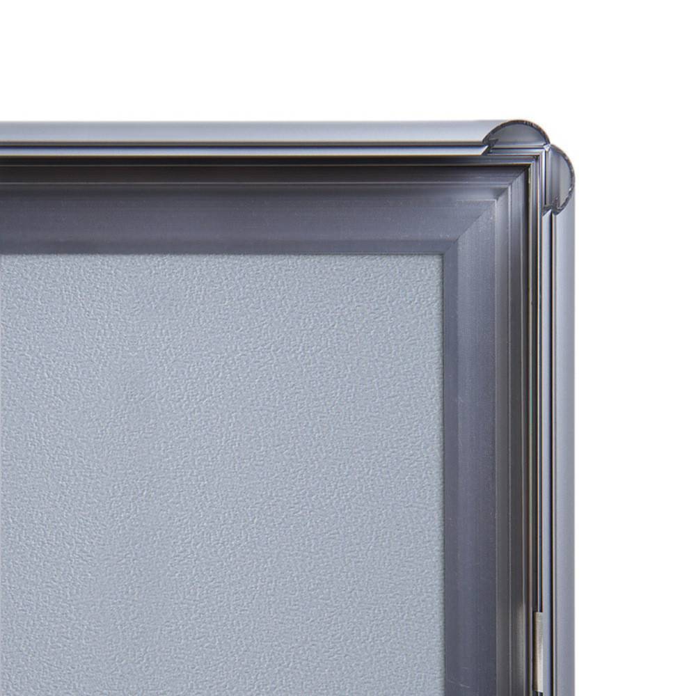 Eine Nahaufnahme einer metallischen Bilderrahmenecke, die ihre glänzende Oberfläche und geometrisches Design zeigt.