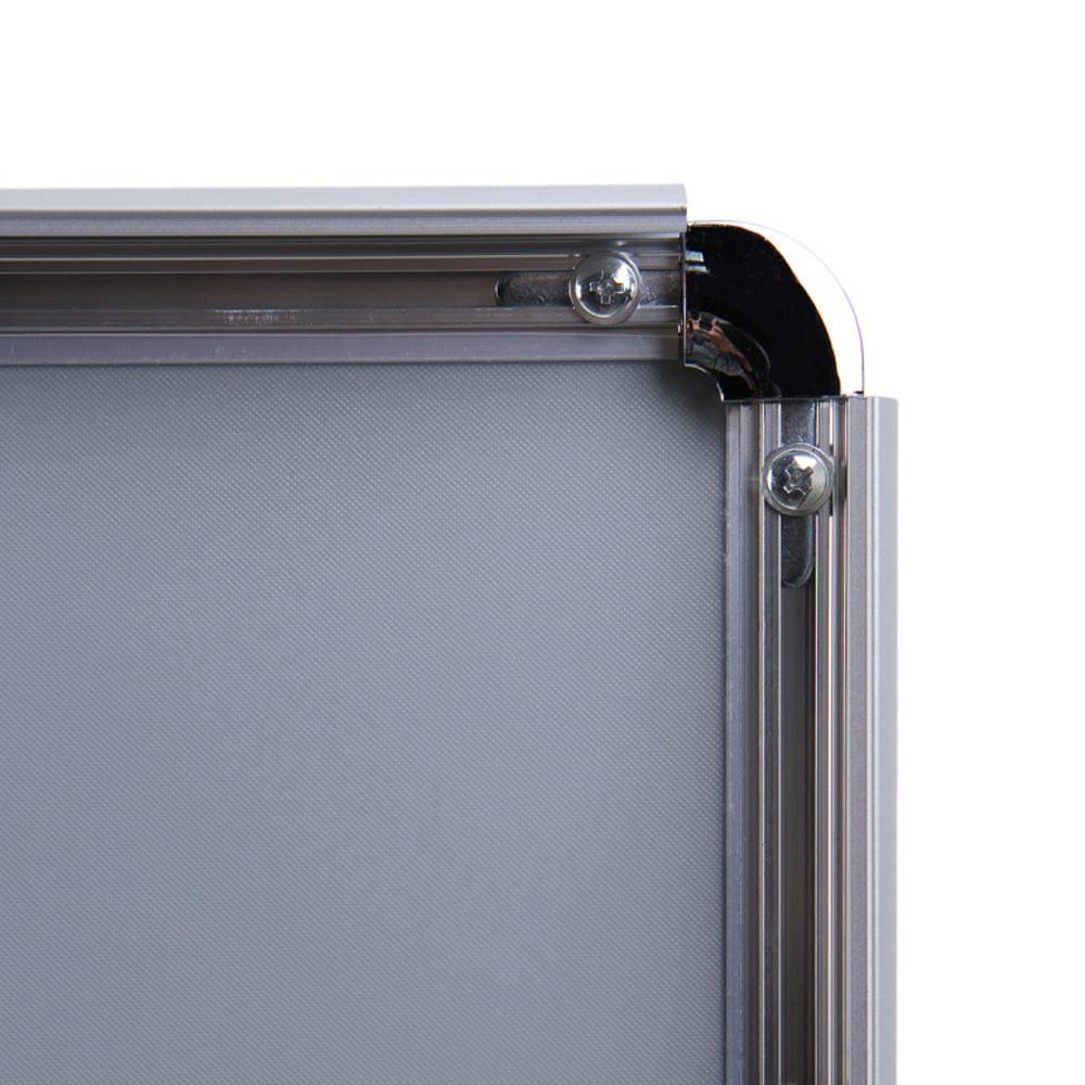 Nahaufnahme einer Aluminium-Rahmenkante mit sichtbaren Schrauben, die ein glatte, graue Platte sichern.