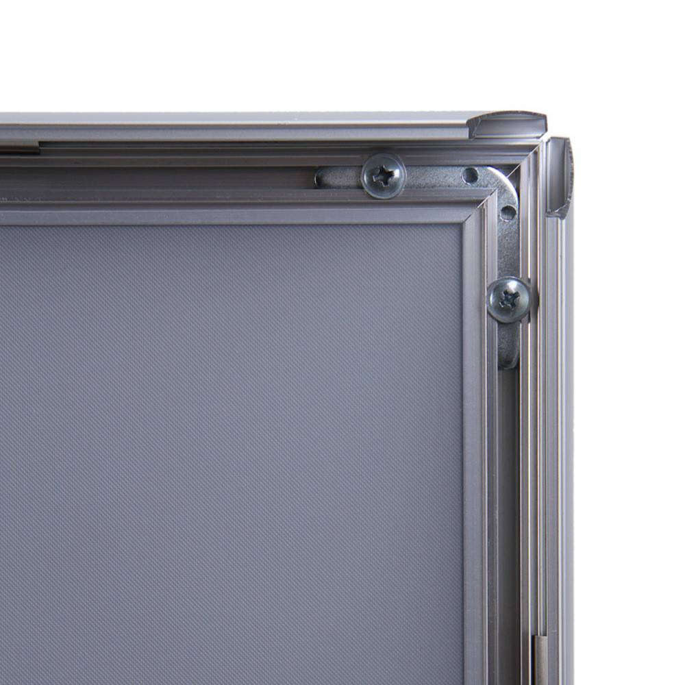 Eine industrielle Metallrahmenecke mit silbernen Schrauben, die eine robuste Konstruktion zur Schau stellt. Die Oberfläche ist ein glattes, graues Panelmaterial.