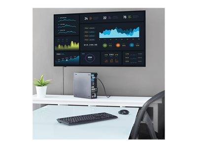Modernes Büro mit digitalem Dashboard, das verschiedene Grafiken und Datenpunkte auf einem großen Bildschirm anzeigt, Computeraufbau auf einem weißen Schreibtisch.